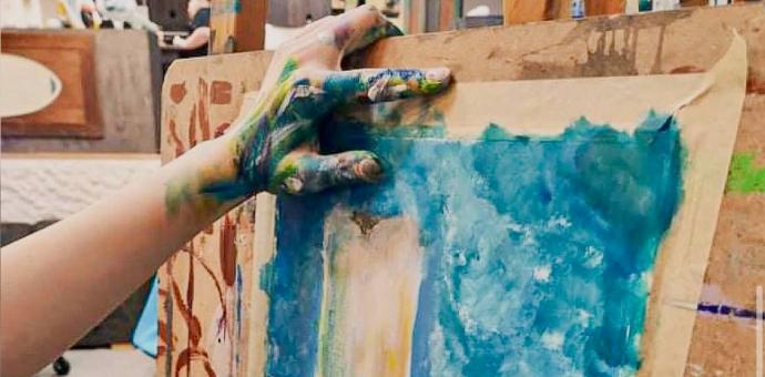 Lapse värvine käsi toetub maalile